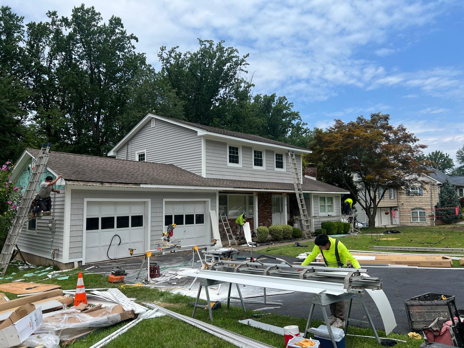 Luis Construction crew unpacking and organizing siding and soffit materials on-site
